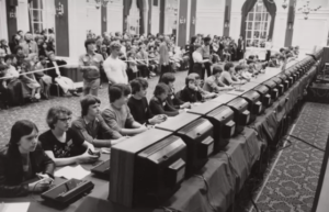 Torneio de space Invaders, 1980, FOTO EM PRETO E BRANCO, v´carias pessoas em frente a computadores, distribuidos em duas fileiras